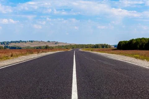 Straight paved road with markings, going into the distance through Stock Photos