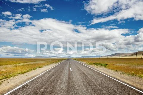 Straight road goes to horizon and mountains Stock Photos
