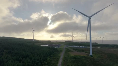 Straight Road Leading Through Onshore Wind Farm with Sunlight Piercing Through Vidéo 343899131