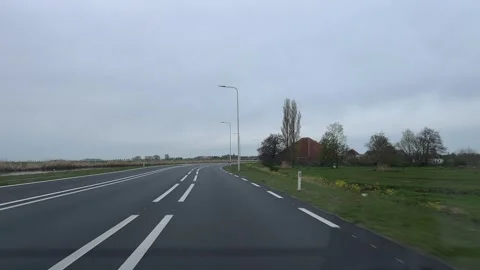 Straight road in an open landscape under an overcast sky with neutral and calm 库存影片 342756538