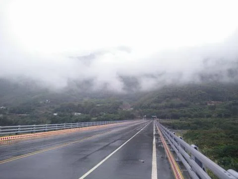 Straight road surrounded by clouds Foto stock