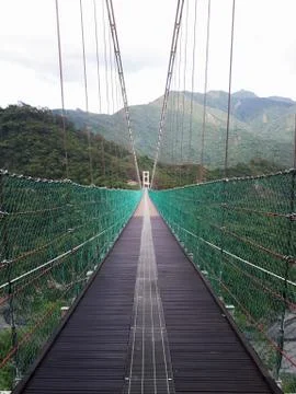 Straight suspension bridge in the valley Stock Photos