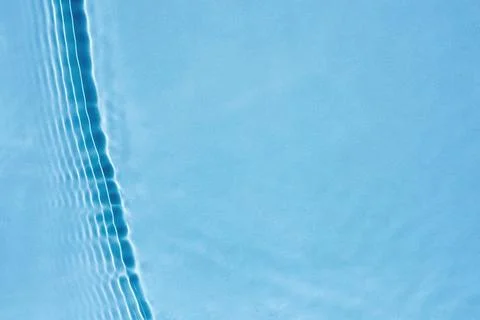 Straight vertical wave, ripples on surface of transparent blue clear water Stock Photos