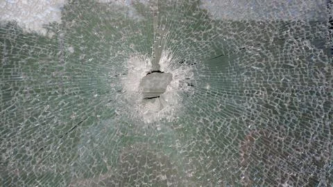 Strained glass broken window with a hole in the middle from explosion splinte Stock Photos