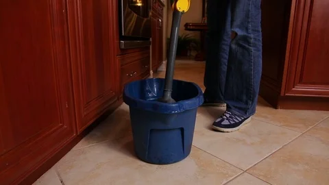 Straining and putting mop in bucket. Liquid cleaning chemicals. wide Stock Footage 106835112