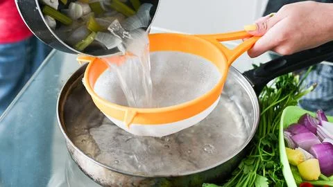 Straining a delicious fish soup called Chilcano Peruvian Food. Stock Photos