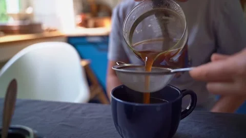 Straining freshly brewed coffee through a strainer. Stock Footage 306309245