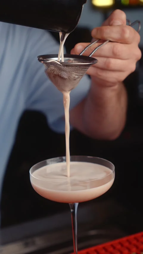 Straining Fruit Puree into Cocktail Glass Stock Footage 342521886
