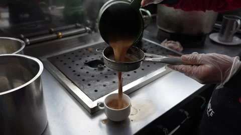 Straining hot tea into serving cup Video stock 310608811
