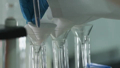Straining the liquid through the filter into the glass laboratory miracle. Stock Footage 264994095