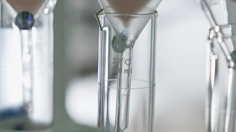 Straining the liquid through the filter into the glass laboratory miracle. Stock Footage 278261319