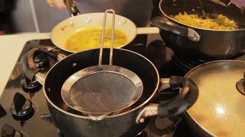 Straining out solid bits from gravy for dinner Stock Footage 88389338