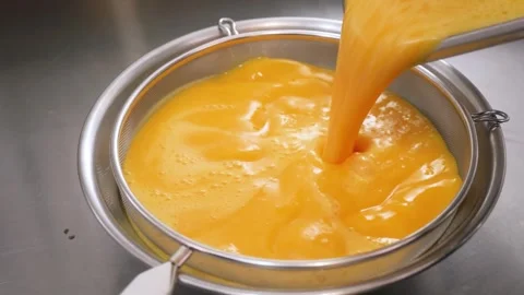 Straining Silky Orange Fruit Curd for Gourmet Dessert Pie Stock Footage 337751426
