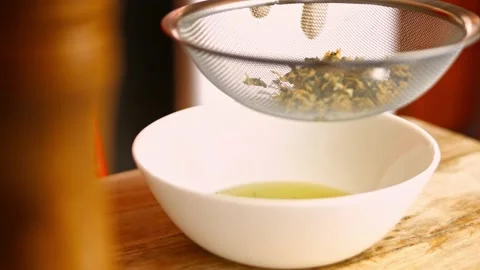 Straining through a sieve the fried garlic and chopped rosemary leaves. Process Stock Footage 151335954