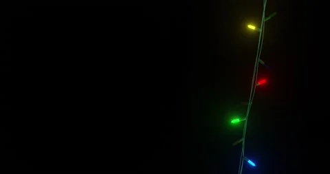 Strand of coloured christmas string lights flashing on black background, copy Stock Footage 253158388