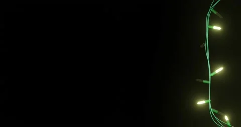 Strand of yellow christmas string lights flashing on black background, copy Stock Footage 253158427