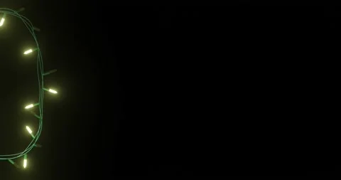 Strand of yellow christmas string lights flashing on black background, copy Stock Footage 253158445