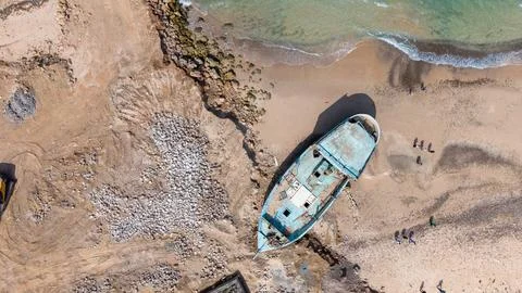 Stranded blue boat on sandy beach Stock Photos