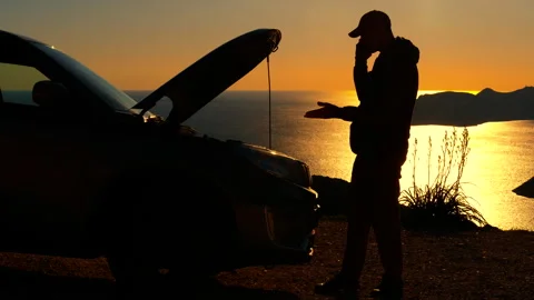 Stranded man calling for help with broken car at sunset Stock Footage 332791296