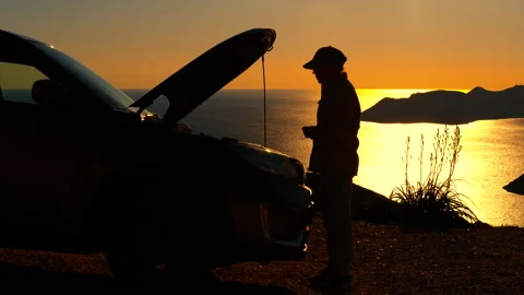 Stranded man calling for roadside assistance at sunset Stock Footage 345169641