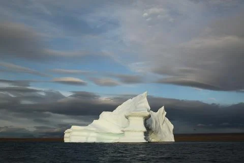 Stranded tabular iceberg and ice near evening in arctic landscape, near Pond Stock Photos
