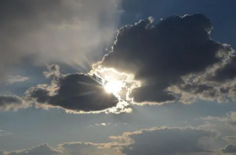 Strange clouds, a cloud trying to swallow the sun. Stock Photos