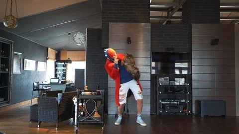 A strange guy is dancing at home with a cat under his arm Stock Footage 128698676