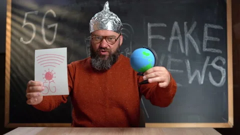A strange man in a foil hat with a Stop 5G poster. Conspirational fake news Video stock 154648592