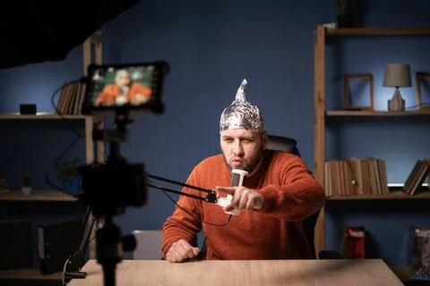 Strange man in a protective foil cap filming commercial video vlog, vlogger r Stockfoto's