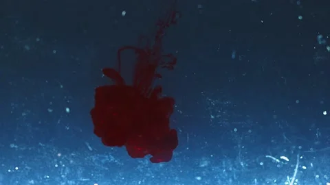 Strange red liquid falling in blue water. Abstract background Stock Footage 136233856