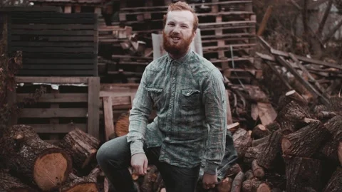 Strange redhead curly guy smokes on the sawmill and expressive talks to a camera Stock Footage 141069852