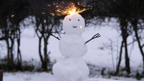 Strange small snowman with burning head, bright sparks fly around from top Stock Footage 83557896