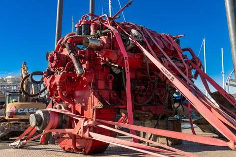 Strapped red industrial engine on dock under blue sky Fotos Stock