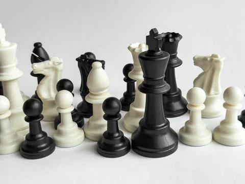 Strategic chess game setup featuring black and white pieces on gray background Stock Photos