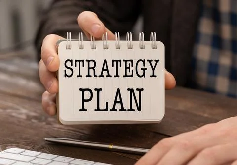 STRATEGY PLAN text on sticker in hand with pen, keyboard. Business concept. Foto stock