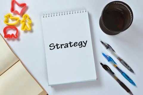 Strategy text on notepad with office accessories. Business motivation, inspir Stock Photos