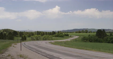 Stratocumulus clouds over a Wyoming road with Devil's Tower in background at Stock Footage 59331481