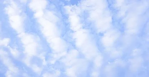Stratocumulus clouds overhead against a blue sky Stock Photos