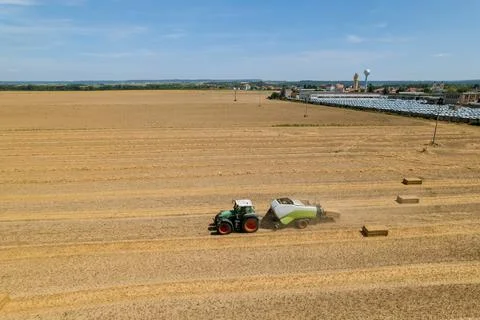 Straw is baled and loaded onto trucks for delivery to storage facility. Stock Photos