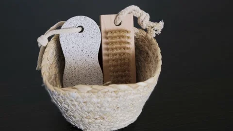 A straw basket containing a foot massage brush with white pumice stone. Natural Stock Footage 233898809