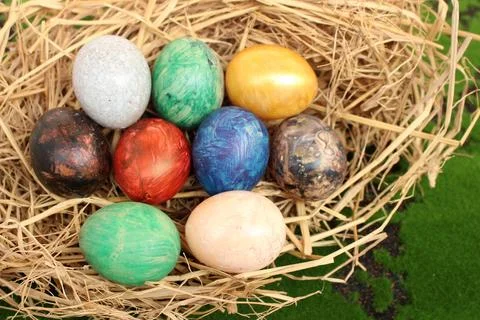 Straw basket with easter eggs on grass background Stock Photos