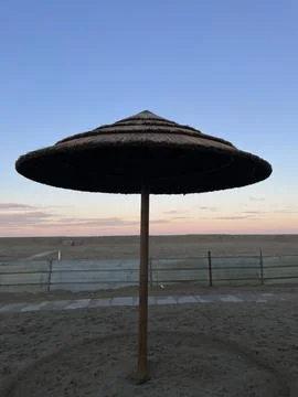 Straw Beach Umbrella at Sunset on Empty Beach in Cesenatico Italy Stock Photos