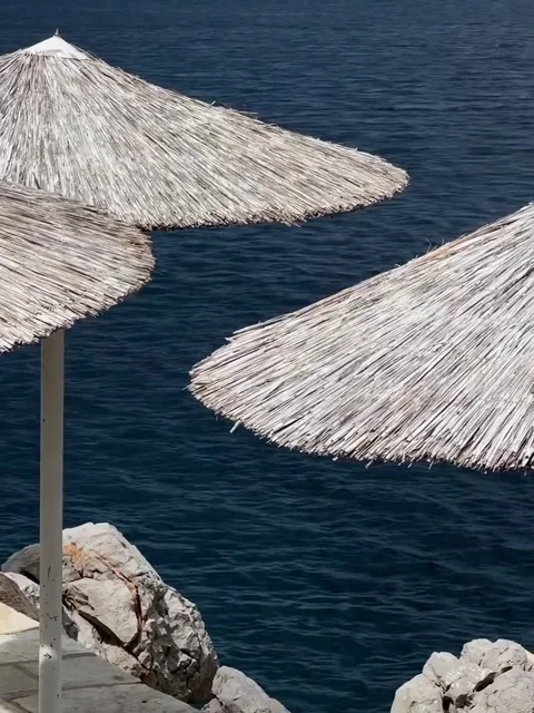 Straw Beach Umbrellas Overlooking Deep Blue Sea Stockbeeldmateriaal 340263942