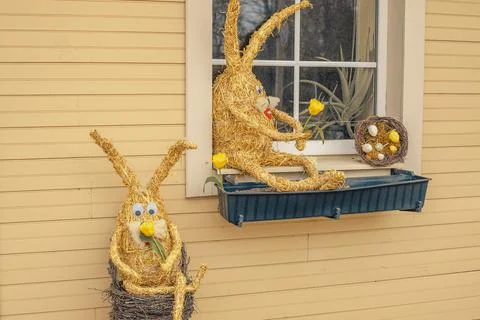 Straw bunny by the window as decor for Easter. Stock Photos