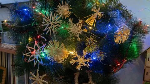 Straw Christmas Ornaments on Tree. Rustic decorations on Christmas tree. Garl Stock Photos