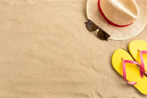 Straw hat and flip flops, on sand background. Beach vacation concept .Top vie Stock Photos