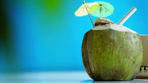 Straw hat and fresh young coconut with straw , umbrella ready for drink. Stock Footage 147044902