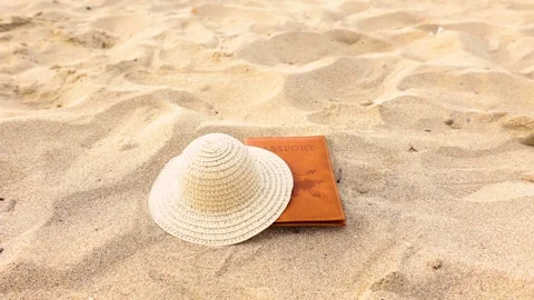 Straw hat and passport falling on the sand Stock Footage 286106229