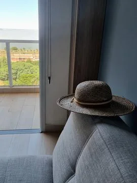 Straw hat on the back of a sofa Stock Photos