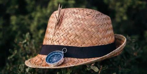 Straw hat with a compass on a natural background. Concept of traveling, trave Stock Photos